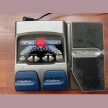 Stříbrný kytarový procesor s modrými spínači a expresním pedálem. Na přístroji je nápis RP80 MODELING GUITAR PROCESSOR a logo DigiTech na pedálu i sp…