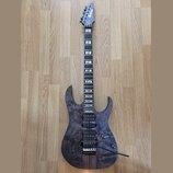Elektrická kytara s tmavě fialovým průsvitným povrchem s viditnou strukturou dřeva. Na hlavě hmatníku je bílý nápis Ibanez. Nástroj má dva humbuckery…