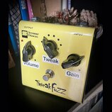 Žlutý kytarový efekt s nápisem TweakFuzz. Na horní části jsou vidět nápisy OUTPUT a INPUT a logo Seymour Duncan. Přístroj má tři ovládací knoflíky s…
