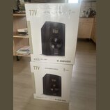 Dvě bílé krabice od studiových monitorů, jedna umístěná nad druhou. Na obou je zobrazen černý reproduktor a nápisy T7V, ADAM AUDIO a T SERIES (na hor…