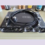 Černý zvukový interface Line 6 UX2 s kovovými ovratky. Na přední straně jsou viditelné nápisy MICROPHONE INPUTS 1/L, 2/R, +48V a INSTRUMENT INPUT NOR…