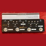 Černý efektový pedál s nápisem MOSKYAudio®. Zařízení obsahuje čtyři stoupací spínače označené jako REVERB, DELAY, OD a DS. Na horní části jsou umístě…
