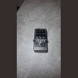 Černý kytarový efekt s nápisy METAL MUFF a electro-harmonix NEW YORK CITY, USA. Na horní straně jsou čtyři černé ovládací knoflíky a popisky TREBLE,…
