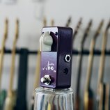 Fialový efekt pedál s kovovým povrchem a bílým knoflíkem. Na přední straně je bílý nápis „pickle vibe TM“. V dolní části se nachází kovový spínač a n…