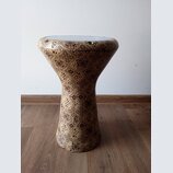 Fotografie zobrazuje buben typu djembe s tělem potaženým vzorníkovou tkaninou v hnědých a béžových odstínech. Horní hrana je zakončena světlým napína…