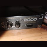 Černý rackový přístroj s nápisy SERIES 9000 a Guitar Pre-amp Model 9001. Na předním panelu jsou dva černé otočné ovratky s popisky OUTPUT, MIX a FULL…