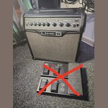 Černý kytarový kombo zesilovač s nápisem LINE 6 a označením modelu SPIDER IV 15. Před zesilovačem je umístěn černý nožní spínací pedalboard značky LI…