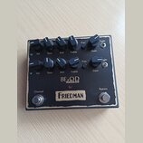 Černý kytarový efekt s nápisy BE O.D deluxe a FRIEDMAN. Na horní straně se nachází dvě řady ovládacích knoflíků s popisky Vol, Bass, Mid, Treble, Pre…