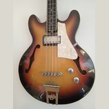 Polodupatá elektrická basová kytara s barevným přechodem od žluté přes červenou k černé. Nástroj má bílý perleťový pickguard, jeden snímač a dva ovlá…