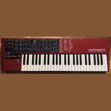 Červený syntetizátor s klaviaturou. Na pravé straně je bílý nápis „nord lead 4 performance synthesizer“. Horní panel obsahuje množství černých ovrato…