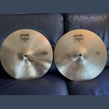 Dvě mosazné činely s viditelným broušením povrchu. Oba mají v horní části logo paiste Twenty a nápis TRADE MARK MADE IN SWITZERLAND. Levý činel má vp…
