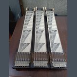 Tři stejné hmatníky pedal steel guitar z tmavého dřeva s bílými vložkami a černým rastrem. Každý hmatník má v horní části čtyři bílé ladičky a v doln…