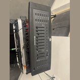 Černý DMX kontrolér s ovládací plochou obsahující posuvníky, tlačítka a displeje. Na přístroji jsou viditelné nápisy DMX OPERATOR a SCENE1, doprováze…