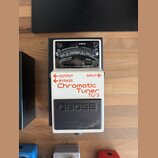Bílý kytarový pedál s černým spínacím tlačítkem a analogovým ukazatelem. Na zařízení jsou nápisy OUTPUT, INPUT, BYPASS, Chromatic Tuner a model TU-3.…