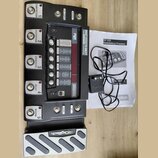 Černý multiefektový procesor s pět vệti spínacími pedály označenými jako COMPRESSOR, DISTORTION, CHORUS/FX, DELAY a REVERB. Na horní části je nápis R…