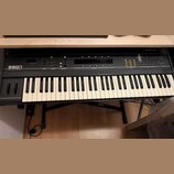 Černý syntetizátor s bílými a černými klávesami. Na levé straně je nápis ESD1 Digital Wave Synthesizer a v pravém horním rohu logo ensoniq. Přístroj…