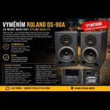 Dva černé studiové monitory značky Roland. Na přední straně obou reproduktorů je v levém horním rohu bílý nápis Roland. Zadní strana jednoho z monito…
