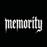 Fotografie zobrazuje bílý nápis „memority“ v gotickém stylu na černém pozadí. Písmo má atypické, svisle protahující se zakončení připomínající stékán…