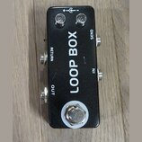 Černý obdélníkový efektový pedál s nápisem LOOP BOX. Na horní straně jsou dvě kontrolky a symbol napájení, v dolní části je kovový spínací tlačítko.…