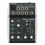 Černý mixážní pult značky behringer s označením XENYX 502S. Horní část obsahuje vstupy MIC1, LINE IN 2/3, LINE IN 4/5 a výstupy MAIN OUT a PHONES. Sp…