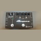 Černý kytarový pedál s bílými nápisy a logem Ampeg. V horní části jsou ovládací knoflíky s popisky Drive, Blend, Volume, Bass, Mid, Treble a AUX Leve…