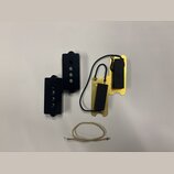 Fotografie zobrazuje dvě černé plastové krytky s otvory, zlatý kovový základ s dvěma černými pěnovými vložkami a bílý kabel. Na komponentech nejsou ž…