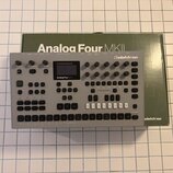Stříbrný stolní syntetizátor s nápisem Analog Four MKII a logem elektron. Zařízení má černý displej, několik otočných knoflíků a řadu tlačítek v doln…