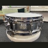 Chromovaná bubnová sada s bílým obsahem. Na korpusu je oválný štítek s nápisy DYNA-SONIC, SERIAL NO. 7491 a CUSTOM BUILT. Povrch chromu vykazuje znám…
