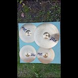 Sada čtyř mosazných činelů značky Paiste z řady pst 3. Na činelech jsou viditelné nápisy paiste a pst 3, přičemž u největšího je uveden text 20 RIDE.…