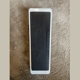 Bílý efekt pedál s černou žebrovanou gumovou plochou. Na gumové části jsou svisle vyrazeny nápisy INSTRUMENT a AMPLIFIER. Povrch bílého rámu vykazuje…