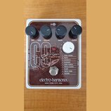 Hnědý kytarový efekt s bílým rámem a nápisem electro-harmonix NEW YORK CITY, USA. Na horní straně jsou čtyři černé ovládací knoflíky s popisky DRY, V…