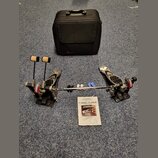 Dvojpedál na bubny v kovovém provedení s černými plošinkami a bílými beatery. Na červených prvcích mechanismu je nápis ELIMINATOR a na přiloženém man…