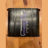 Černý obdélníkový box s žebrovaným povrchem. Na horní straně je bílý a fialový nápis ARTcessories TM, logo s trojúhelníkem a text A R T. Vedle něj je…