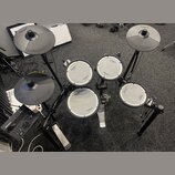 Elektronická bicí souprava značky Roland v černé barvě. Na čelech padů a na činelech je vidět logo Roland, u padů jsou dále nápisy V-Drums a V-Drum.…