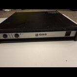 Černý výkonový zesilovač s kovovým šasi. Na předním panelu je nápis „EV Q99 PROFESSIONAL POWER AMPLIFIER“, kontrolky PROTECT a POWER, dva ovratidla p…