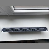 Černá racková DI box s čtyřmi kanály. Na přední straně jsou nápisy CHANNEL A, CHANNEL B, CHANNEL C a CHANNEL D, u každého z nich jsou vstupy INPUT, L…
