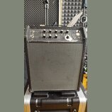 Černý kytarový kombo zesilovač s šedou síťovinou reproduktoru. Na horním ovládacím panelu jsou knofíky s popisky GAIN, BASS, TREBLE, MIDDLE a REVERB,…
