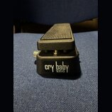 Černý kytarový wah pedál s žebrovaným šlapadlem. Na přední straně je viditelný nápis cry baby a pod ním označení 5350Q. Povrch pedálu je s texturovan…