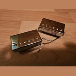 Dva elektrické snímače typu humbucker s chromovaným kovovým krytem. Snímače mají viditelné šestiky pólů a z jejich boku vedou barevné připojovací vod…