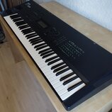 Černý digitální klavír s bílými a černými klávesami. Na horní části je nápis KORG a modelové označení SV-1. Nástroj disponuje displejem, několika ovl…