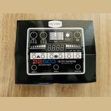 Fotografie znázorňuje krabici s pedalem efektu. Na ní je zobrazen bílý přístroj s nápisy 22500 dual stereo looper a electro-harmonix NEW YORK CITY, U…