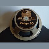Fotografie znázorňuje reproduktor s kovovým rámem v béžové barvě. Na středovém černém krytu jsou nápisy CELESTION LOUDSPEAKERS, G12 G12, Vintage 30 a…