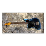 Modrá elektrická kytara s černým pickguardem a hnědým hmatníkem. Na hlavě je viditelné logo Fender a nápis Stratocaster. Kytara má jeden humbucker u…