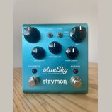 Modře kovový efekt pedál s nápisy blueSky reverberator a strymon. Zařízení má pět černých otočných ovladačů s popisky DECAY, LOW DAMP, PRE-DELAY, HIG…