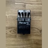 Kytarový efekt reverb v černé barvě s kovovým šasi. Na horní části jsou tři ovládací knoflíky a nápisy CHECK, MODULATE, SPRING, PLATE, HALL, ROOM, SH…