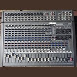 Šedý mixovací pult s nápisy SAMSON a 24 DSP. Pod logem je uveden model TXM80 1000W STEREO POWERED MIXER. Na ovládacím panelu jsou řady bílých a modrý…