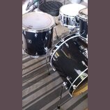 Černá bicí souprava s chromovaným kováním. Na tomare na levé straně je viditelné logo "Ludwig" a nápis "Black Beauty". Souprava obsahuje basové buben…