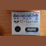 Stříbrný elektronický bicí automat značky BOSS, model Dr. Rhythm DR-3. Zařízení má horní panel s modrými a šedými tlačítky, ovládací knoflík VALUE a…