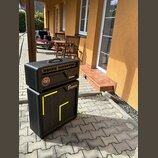 Černý kytarový zesilovač a připojená reproboxová skříň. Na předním panelu zesilovače je nápis Neural, na reproboxu je logo Bogner a žlutý grafický pr…
