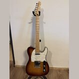 Elektrická kytara typu Telecaster s hnědým slunečním odstínem (sunburst) a výraznou strukturou dřeva. Na hlavě hmatníku je bílý nápis BACY, korpus má…